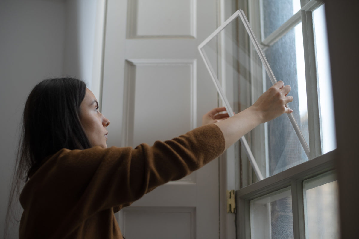 A person lifting a Retro Pane into place in a sash window
